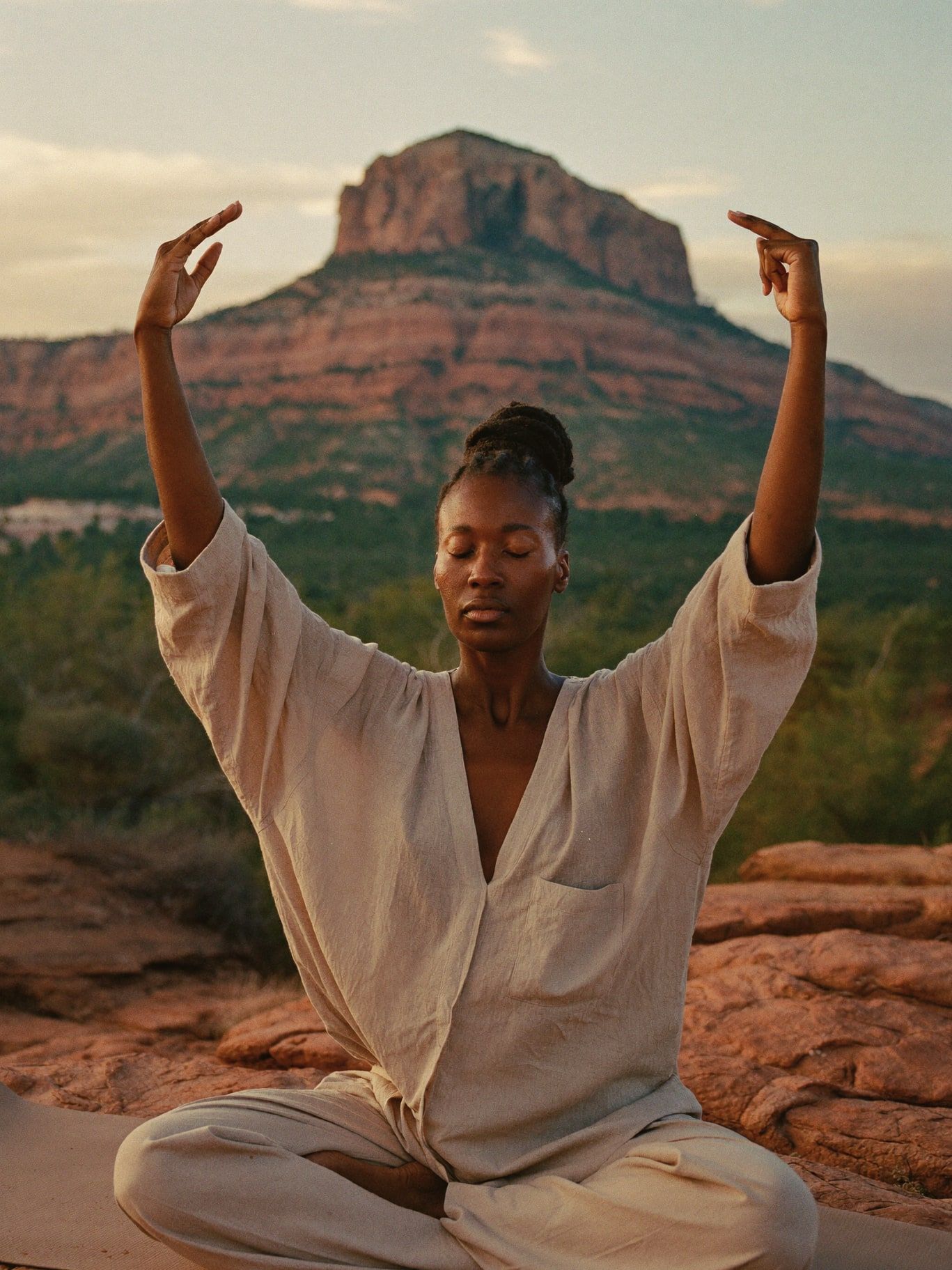 A woman practicing qi gong at sunrise on red rock