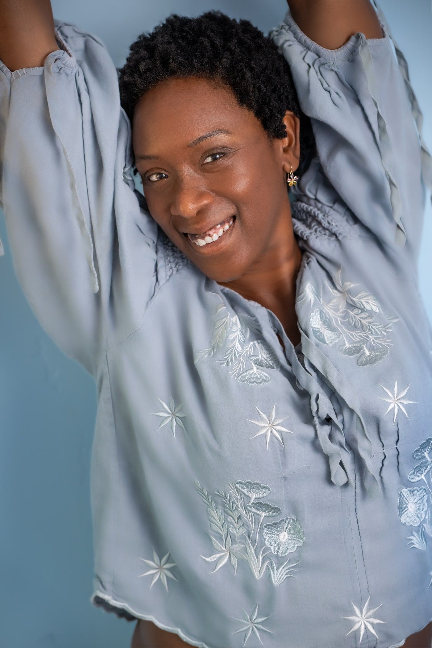 Yolessa, founder of Sedona Healing Arts, smiling with her arms raised